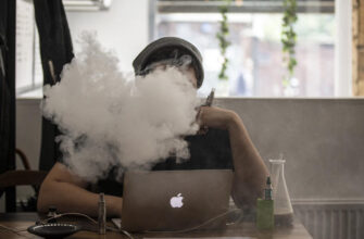 курение электронной сигареты за ноутбуком. Фото